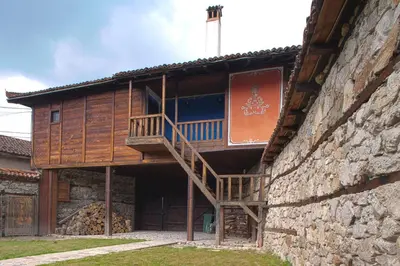 a wooden building with a staircase on the side of it at ЧОЛАКОВАТА КЪЩА in Koprivshtitsa