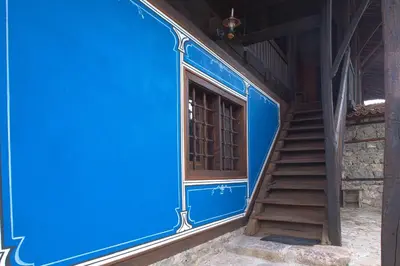 a blue train with a staircase next to a building at ЧОЛАКОВАТА КЪЩА in Koprivshtitsa