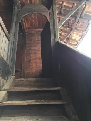 an attic staircase in a wooden building with a door at ЧОЛАКОВАТА КЪЩА in Koprivshtitsa