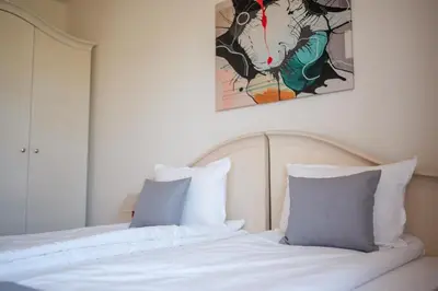 a bed with two pillows and a painting on the wall at KATERINA guest house in Kocherinovo