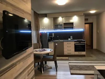 a small kitchen with a small table and a television at Apartments Park Place in Sandanski
