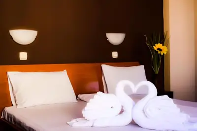 two swans made out of towels sitting on a bed at Hotel Alexander in Sofia
