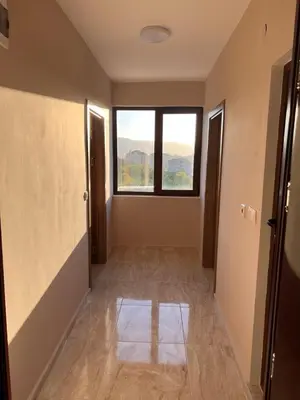 an empty room with a window and a hallway at Вихрен-стаи и апартаменти за гости in Sandanski