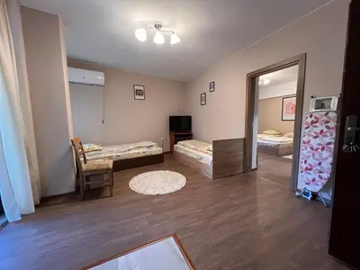 a living room with two beds and a mirror at Вихрен-стаи и апартаменти за гости in Sandanski