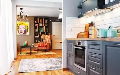 a kitchen with gray cabinets and a living room at Stylish and High-end Designer Apartments in City Center in Sofia