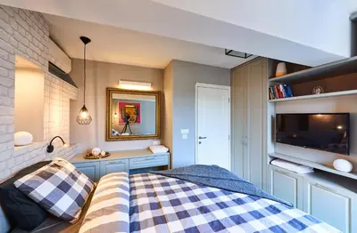 a bedroom with a bed and a tv on a wall at Stylish and High-end Designer Apartments in City Center in Sofia