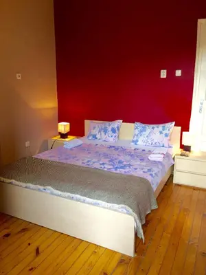 a bedroom with a large bed with a red wall at Interhost Guest rooms and apartments in Sofia