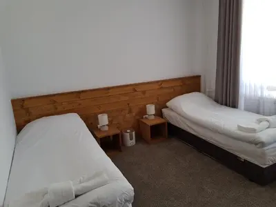 a bedroom with two beds and two tables with lamps at VIP Apartment Stenata Complex in Pamporovo