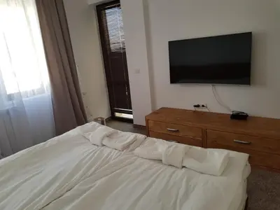 a bedroom with a bed and a flat screen tv at VIP Apartment Stenata Complex in Pamporovo