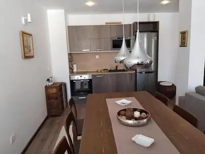 a kitchen and dining room with a table with a bowl of food at VIP Apartment Stenata Complex in Pamporovo