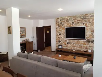 a living room with a couch and a stone wall at VIP Apartment Stenata Complex in Pamporovo