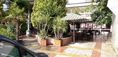 a restaurant with a table and chairs and plants at Heat Complex Family Hotel in Peshtera