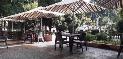 a restaurant with tables and chairs under an umbrella at Heat Complex Family Hotel in Peshtera