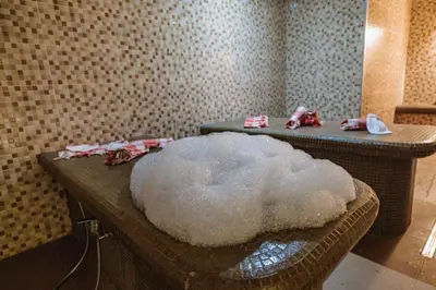 a white sheep sitting on a table in a room at Iglika Hotel & Villas Borovets in Borovets