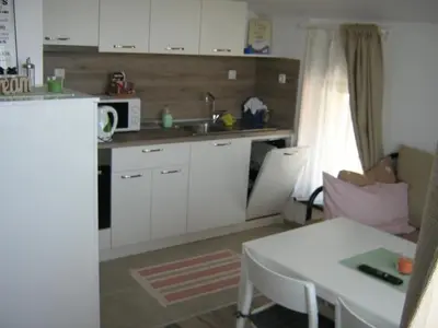 a kitchen with white cabinets and a table and a microwave at Khan Krum House & Apartments for rent in Elin Pelin