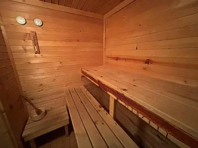 an empty wooden sauna with two clocks on the wall at Chalet Sofia in Borovets