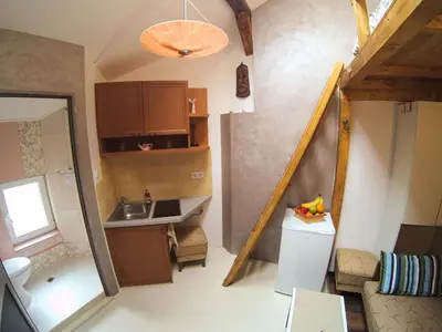 a small kitchen with a sink and a staircase at Vitosha Blvd - Attic Studio in Sofia