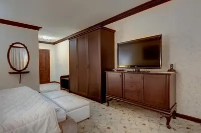 a bedroom with a bed and a flat screen tv at Shiroka Laka Hotel in Shiroka Lŭka