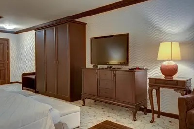 a bedroom with a bed and a flat screen tv at Shiroka Laka Hotel in Shiroka Lŭka