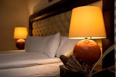 a lamp on a night stand next to a bed at Shiroka Laka Hotel in Shiroka Lŭka