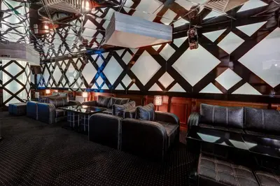 a room with leather chairs and tables and a ceiling at Shiroka Laka Hotel in Shiroka Lŭka