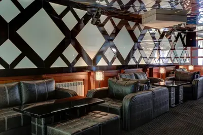 a bar with couches and chairs and a table at Shiroka Laka Hotel in Shiroka Lŭka