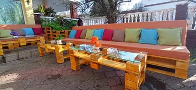 a bench with colorful pillows and a table on a patio at Комплекс 