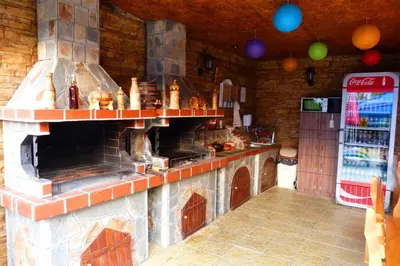 a large kitchen with a stove and a refrigerator at Комплекс 