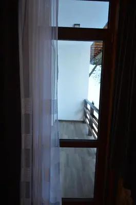 a window with a curtain in a room at Ваканционно селище Ива in Sarnitsa