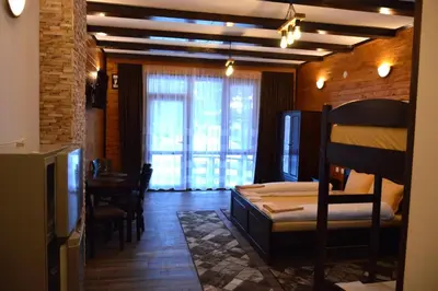 a room with a bedroom with a bed and a table at Ваканционно селище Ива in Sarnitsa