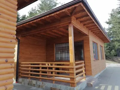 a log cabin with a porch and a large window at Ваканционно селище Ива in Sarnitsa