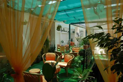 a room with a table and chairs and plants at Kniaz Boris Hotel in Sofia