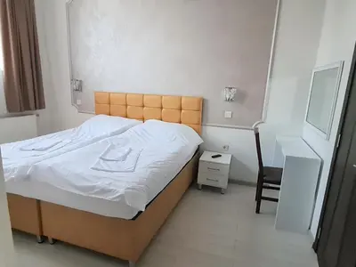 a bedroom with a bed and a desk and a chair at Семеен хотел 