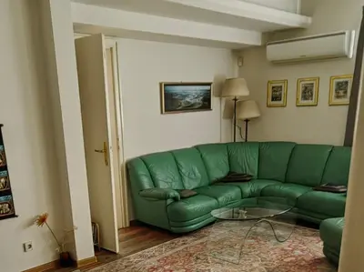 a green couch in a living room with a glass table at Cozy Flat in Sofia