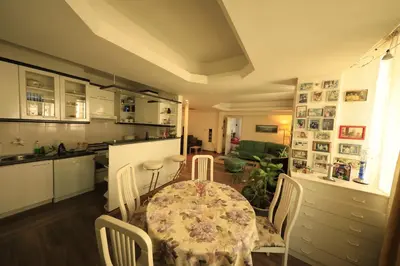 a dining room with a table and chairs and a kitchen at Cozy Flat in Sofia