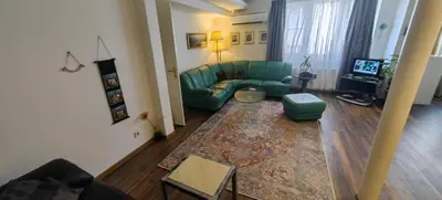 a living room with a green couch and a rug at Cozy Flat in Sofia