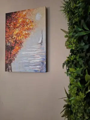 a painting of a sailboat on the water on a wall at Cozy apartment in the heart of Sofia in Sofia
