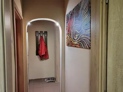 a hallway with a red umbrella hanging on a wall at Cozy apartment in the heart of Sofia in Sofia