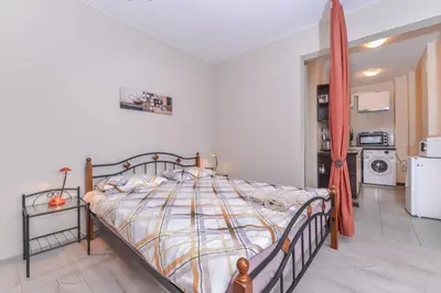 a bedroom with a bed and a kitchen with a refrigerator at Visit Sofia Macedonia Square Central Apartment by Flat Mаnager in Sofia