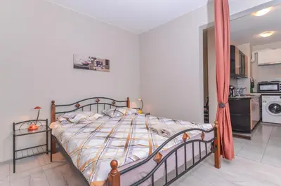 a bedroom with a bed and a kitchen in the background at Visit Sofia Macedonia Square Central Apartment by Flat Mаnager in Sofia