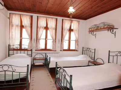 two beds in a room with windows at Despot Slav Hotel & Restaurant in Melnik