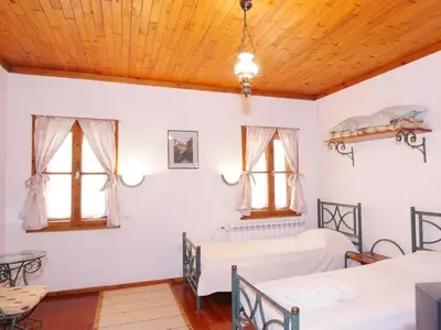 a bedroom with two beds and two windows at Despot Slav Hotel & Restaurant in Melnik