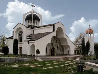 a white church with a cross on top of it at Despot Slav Hotel & Restaurant in Melnik