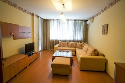 a living room with a couch and a tv at Apartment Geo Milev in Plovdiv
