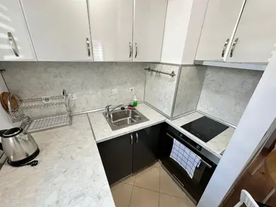 a small kitchen with white cabinets and a sink at White Wood Lodge in Bansko