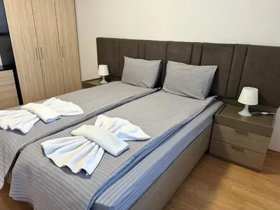a bed with towels and pillows on top of it at White Wood Lodge in Bansko