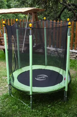 a small trampoline in the grass in a yard at Тодорината къща in Leshten