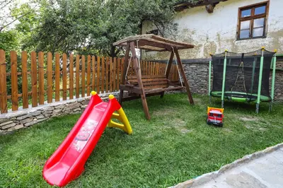 a playground with a slide and a swing at Тодорината къща in Leshten