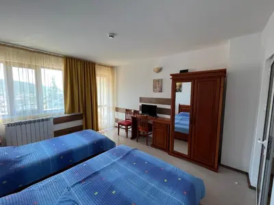 a hotel room with two beds and a desk at Centaur Family Hotel in Rila
