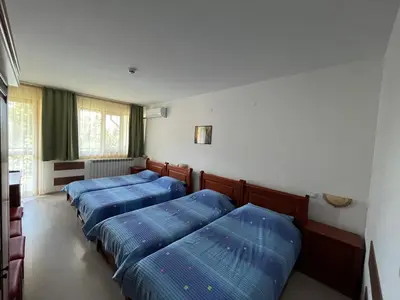 three beds in a room with blue pillows at Centaur Family Hotel in Rila